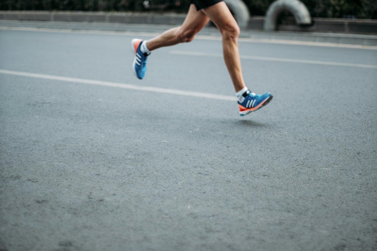 A runner mid-stride on an empty road